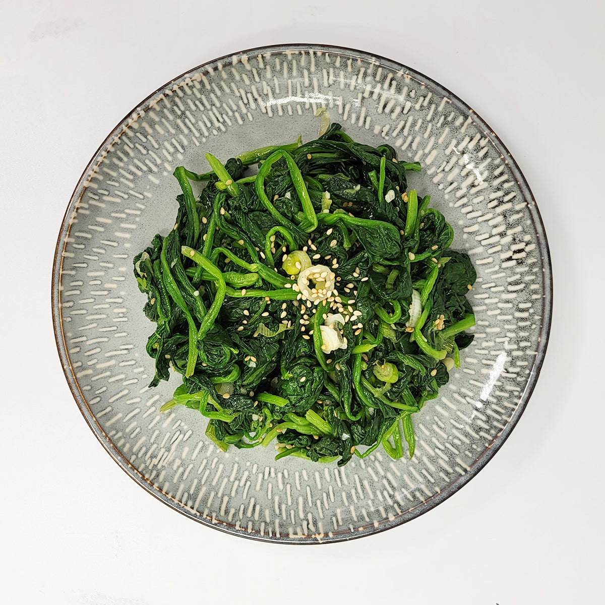Close-up view of Sigeumchi-namul (Korean seasoned spinach) – small family size | Banchan365