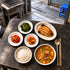 Grilled mackerel and doenjang jjigae meal set with chwinamul greens, seasoned radish, kimchi and rice.