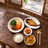 Jeonju-style bibimbap vegetables and grilled Atka mackerel meal set with doenjang jjigae, kimchi and rice.